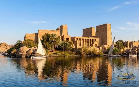 Traditional Nile motorboat approaching the stunning Philae Temple on Agilkia Island