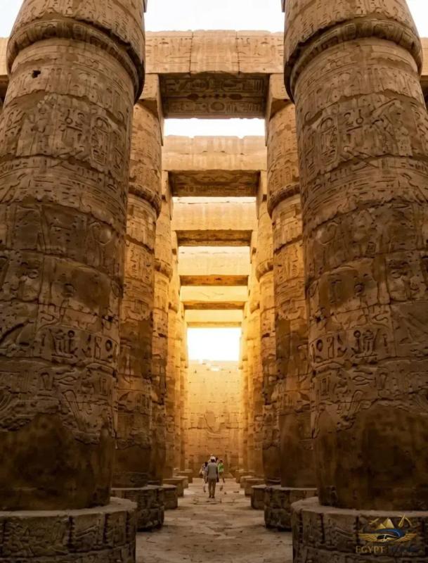 Tourists exploring the massive sandstone columns at Karnak Temple Complex in Luxor