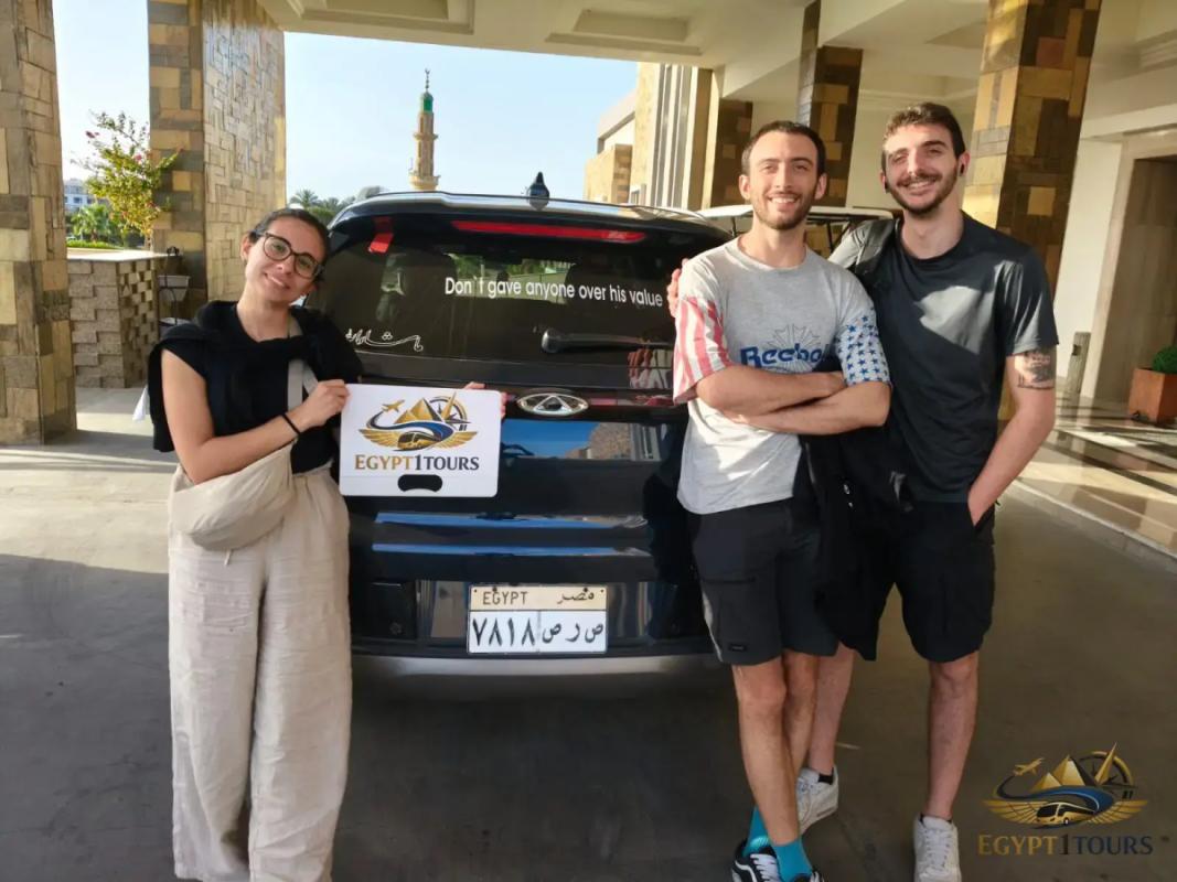 Happy clients standing in front of their private transfer vehicle with Egypt 1 Tours sign