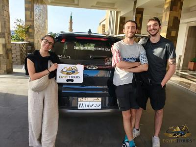 Happy clients standing in front of their private transfer vehicle with Egypt 1 Tours sign